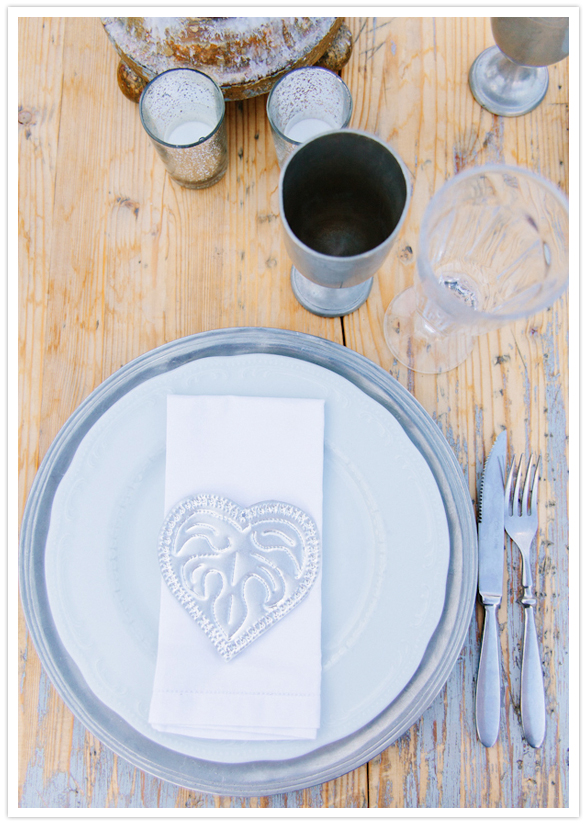 wood table, white plates and silver stamped napkins wood table, white plates and silver stamped napkins