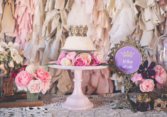 gold crown-topped, white frosted cake with rose accents gold crown-topped, white frosted cake with rose accents