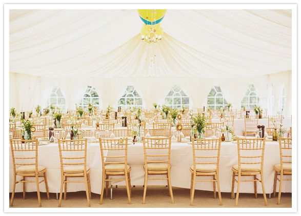 white tent and gold chairs wedding reception style