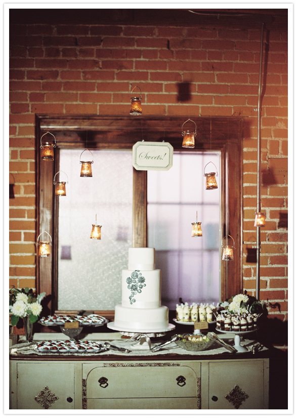 three-tiered white wedding cake and hanging lanterns