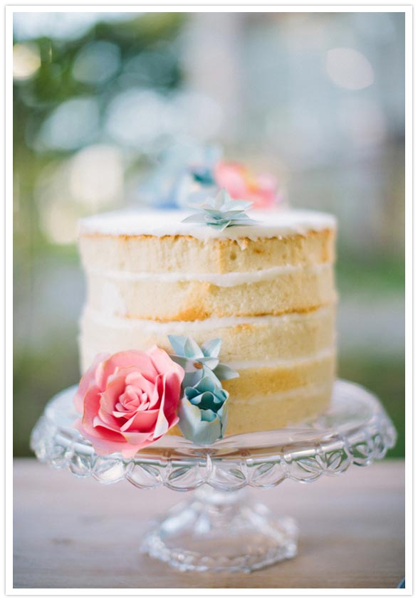 white layer cake with paper flower cake topper