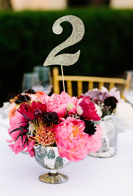vibrant pink floral centerpiece and glitter paper table number