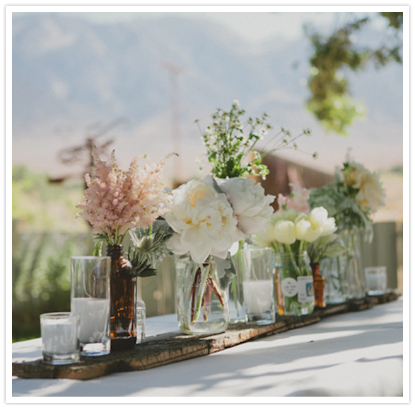 row of flower vases and candle centerpieces