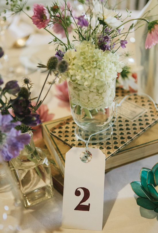 hang tag table numbers, stacked vintage books and wildflower centerpieces