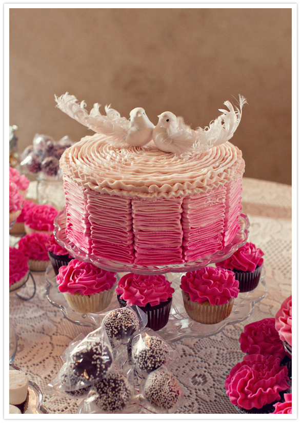 bright pink ruffled wedding cake with love bird topper