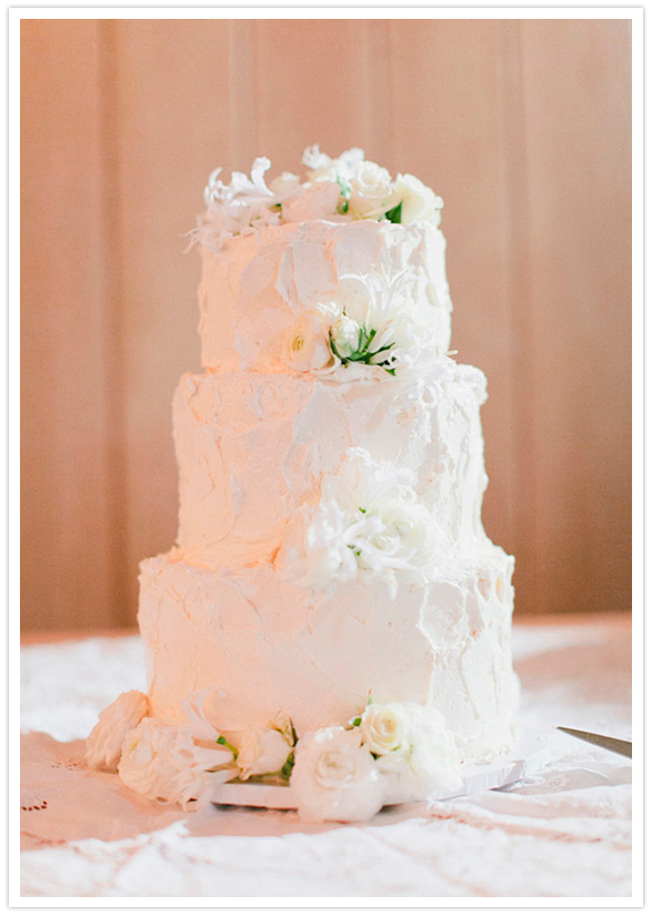 simple white frosted cake and floral accents