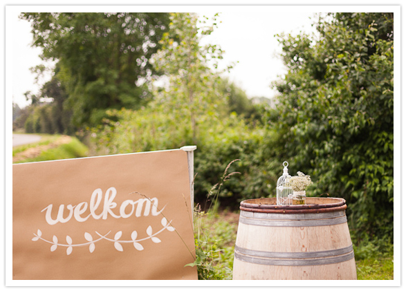 paper welcome sign and barrel tables