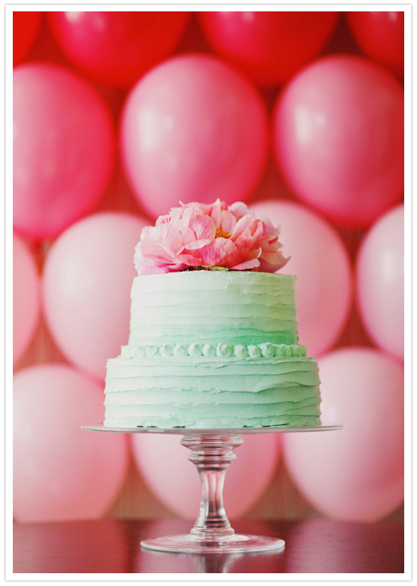 mint green frosted cake and pink peony topper