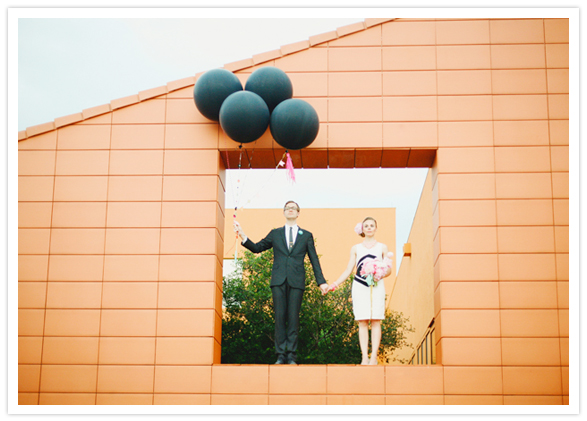 orange brick wall and black balloons