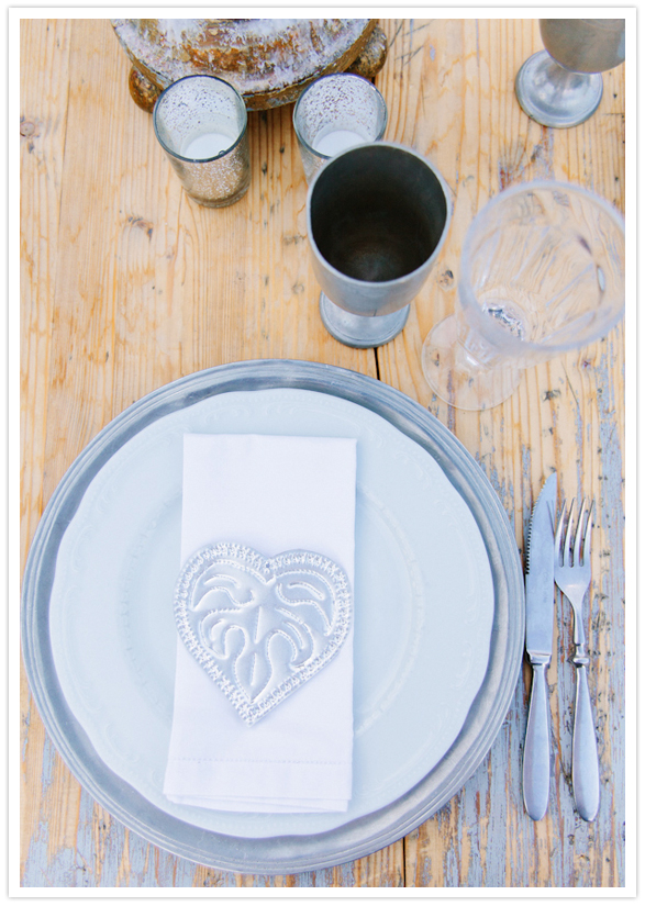 wood table, white plates and silver stamped napkins