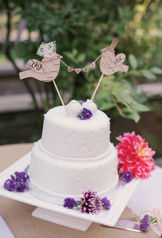 white and purple wedding cake with paper love birds topper | Photo by Michele M. Waite