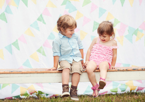 pink ruffled girls jumper and boys khaki shorts and button down