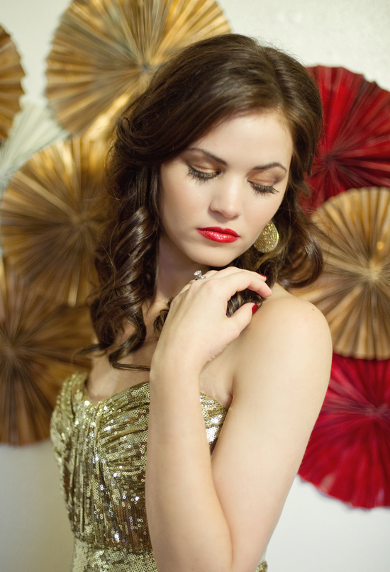 gold sequin dress, red lips, and paper wall decor