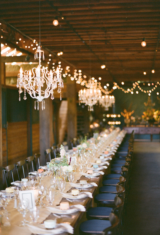 large harvest table and chandeliers reception