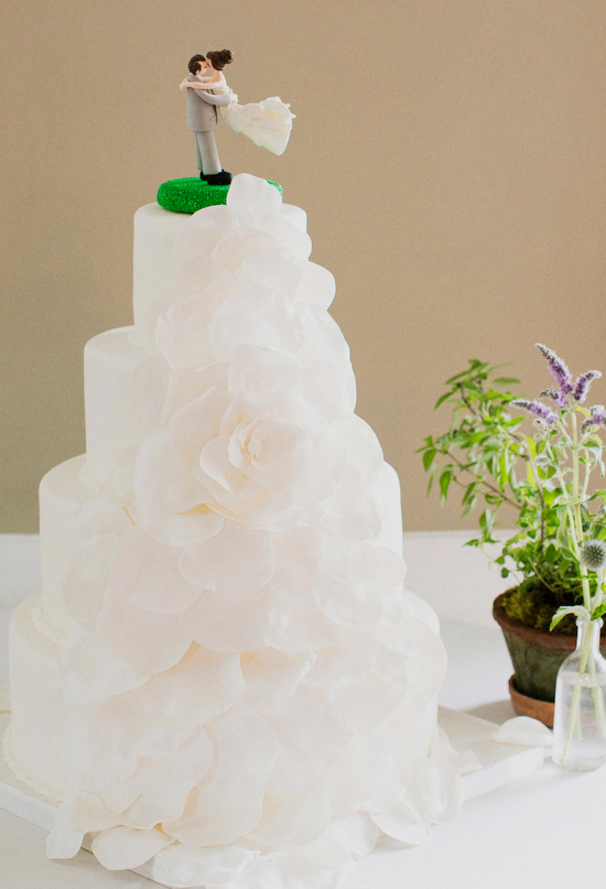 cascading flower wedding cake and quirky cake topper