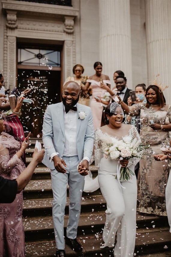 bride in jumpsuit and groom's powder blue suit