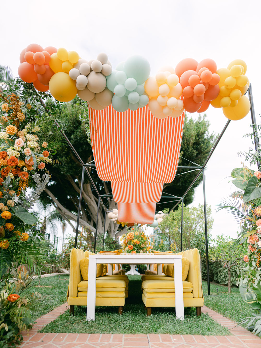 balloon arch and canopy on tablescape for yellow first birthday
