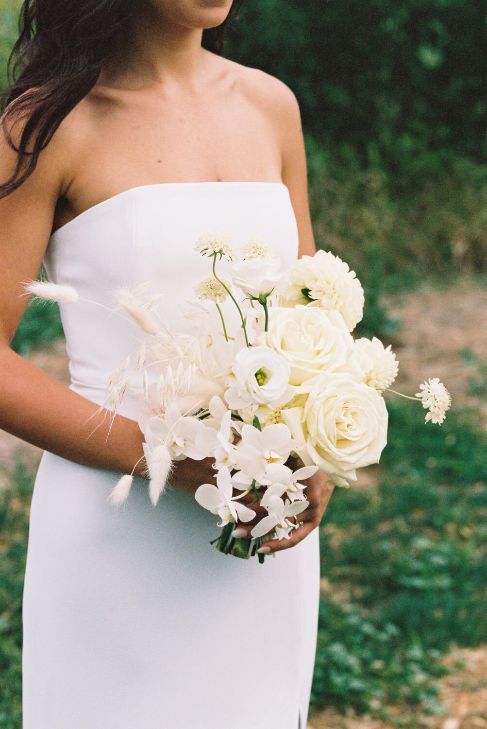 all white bridal bouquet and modern wedding dress
