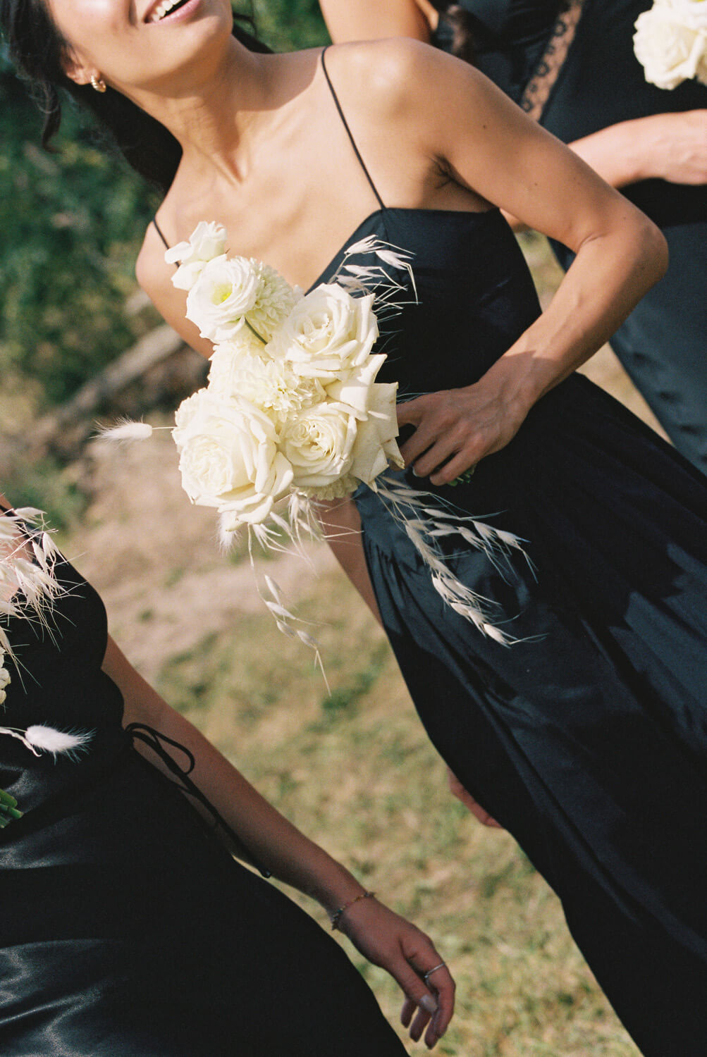 black bridesmaid dress with white rose bouquet
