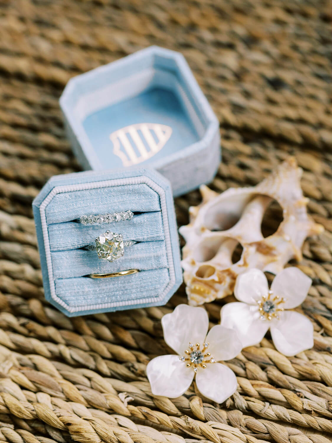 wedding rings in blue ring box and flower earrings for bride
