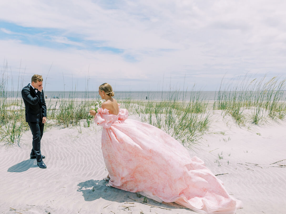 first look on the beach in pink wedding dress