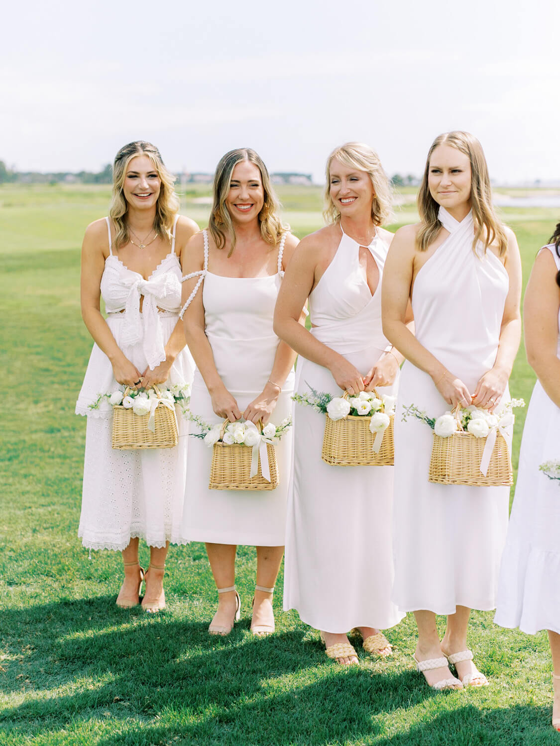 all white bridesmaids dresses with baskets of flowers