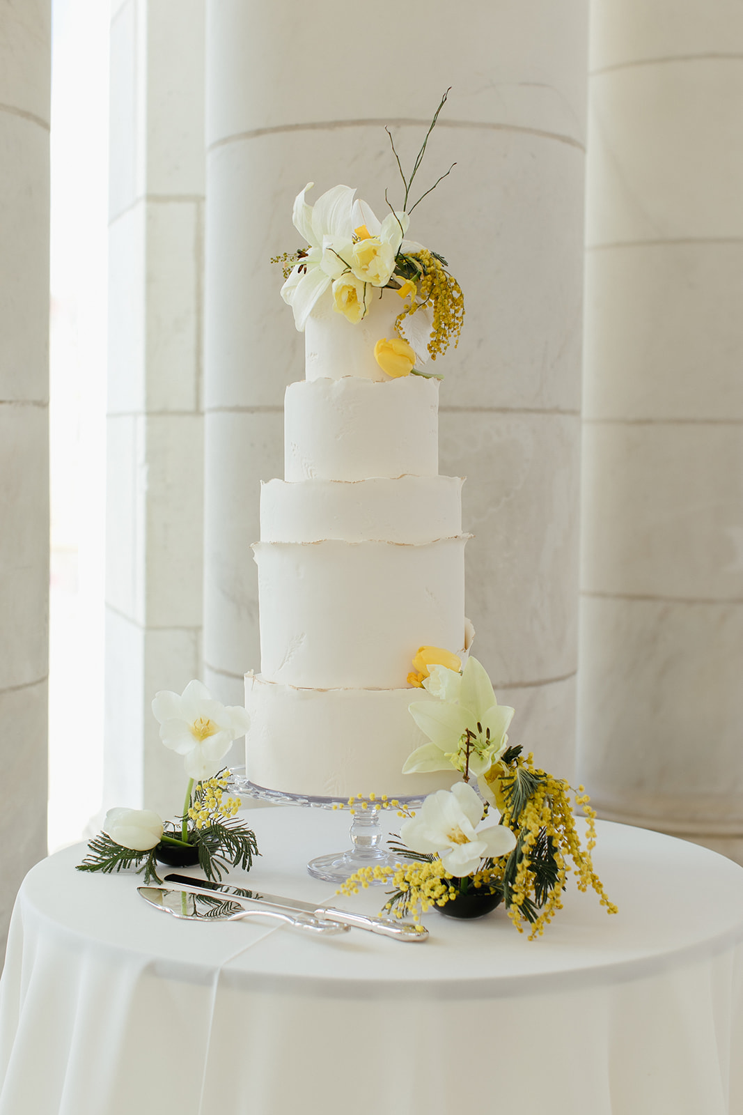 elegant white wedding cake with yellow flowers
