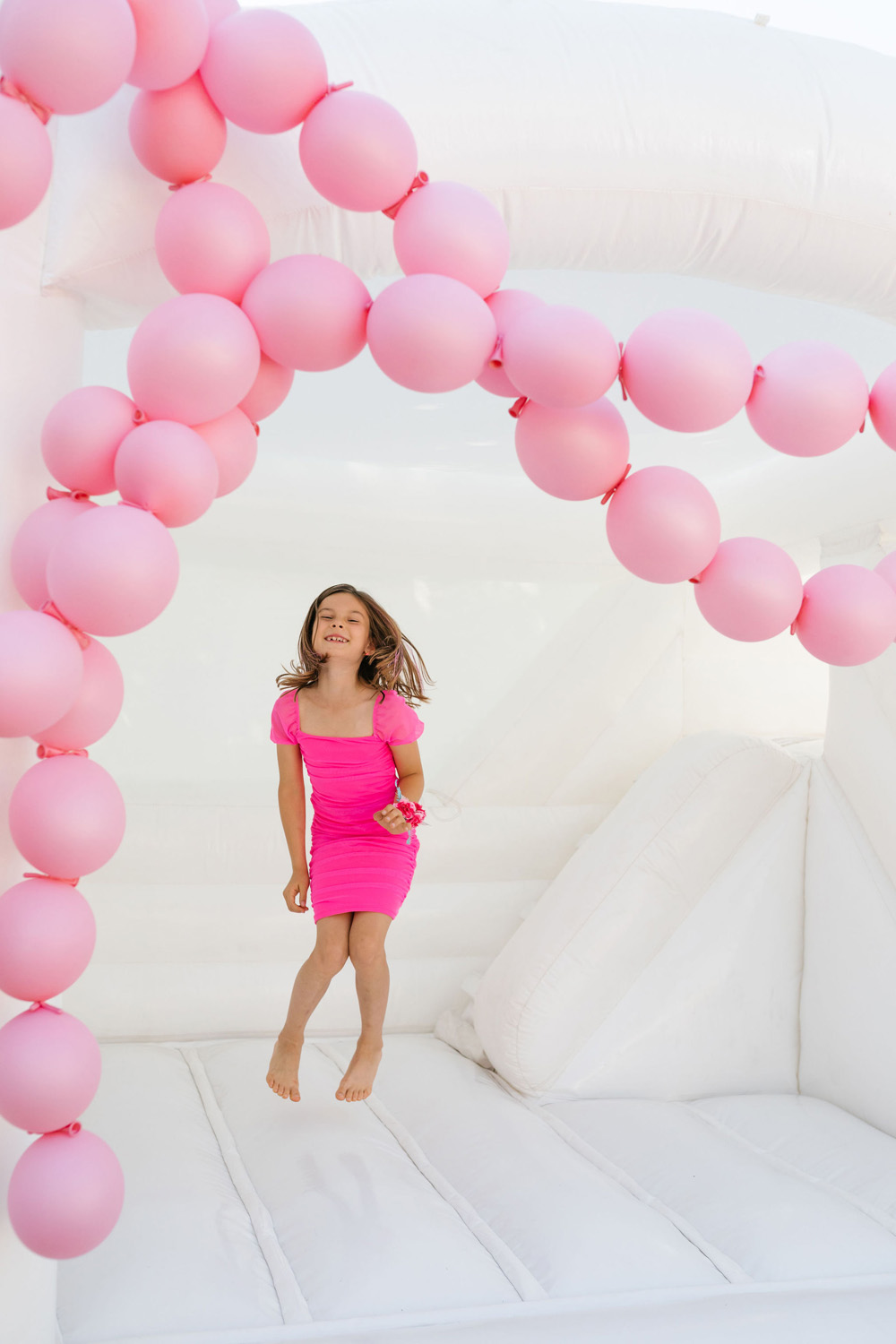 Pink and white bounce house 