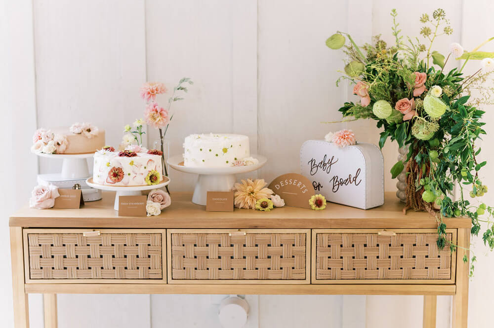 neutral baby shower dessert table with floral cakes