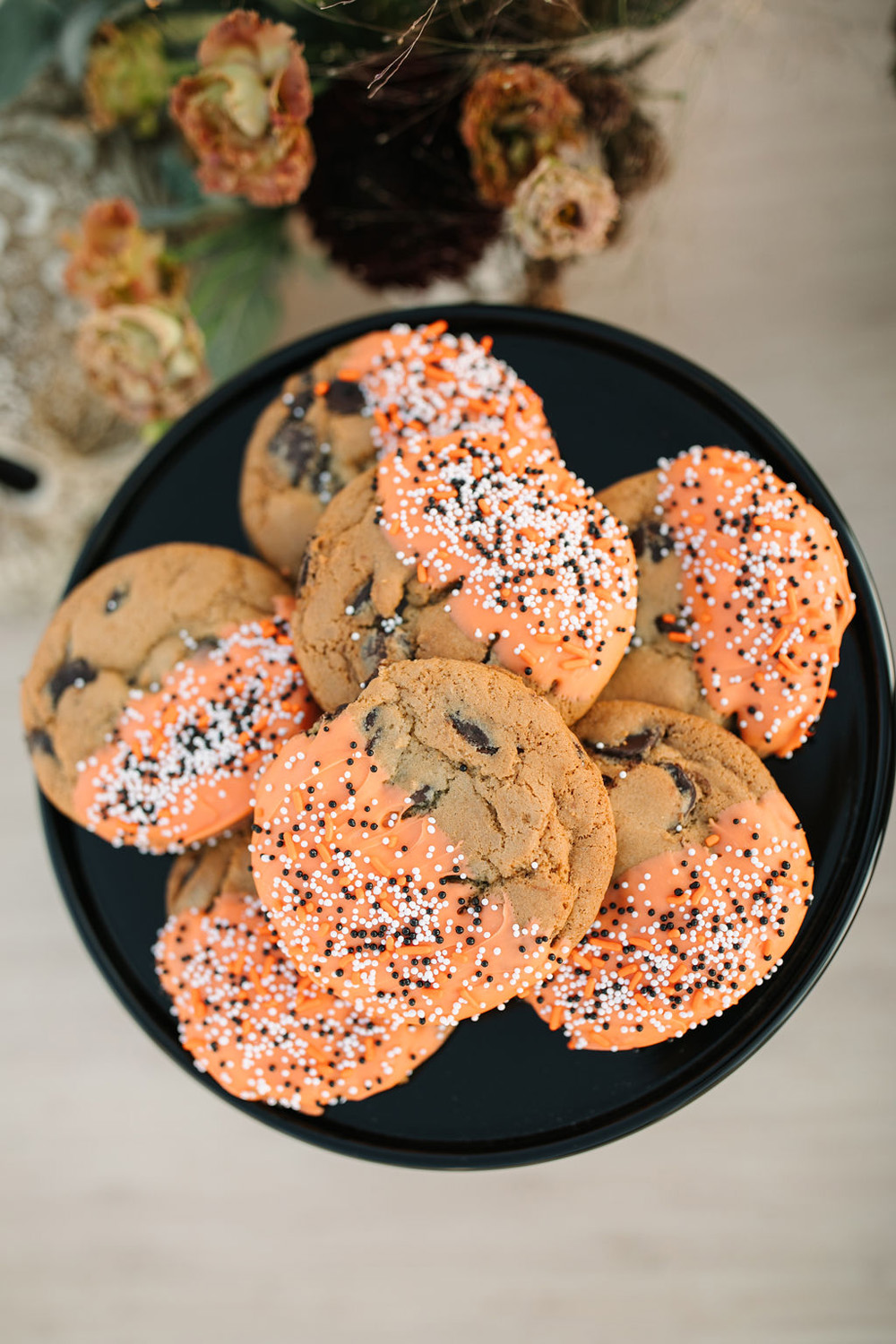 Halloween chocolate chip cookies with orange frosting and sprinkles