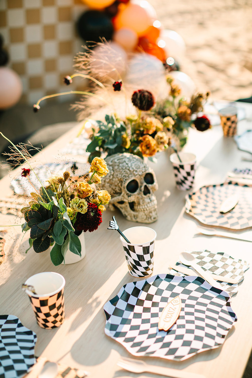 Meri Meri black and white check tabletop decor for "Surf or die" themed halloween party at the beach