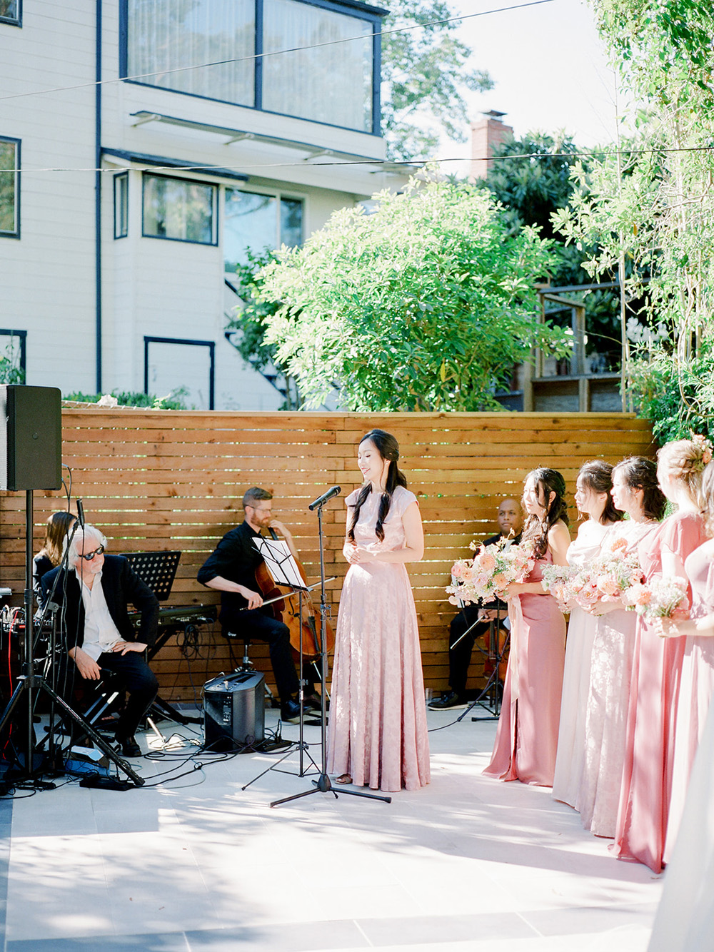 pink bridal party in backyard wedding ceremony