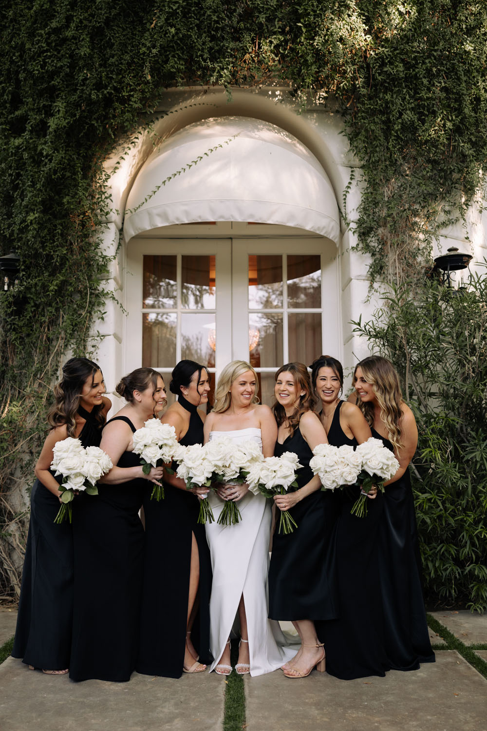 bridesmaids in black with white bouquets