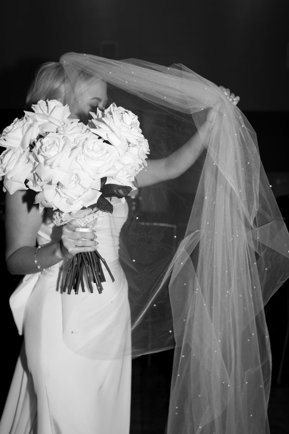 black and white portrait of bride with pearl veil and white roses