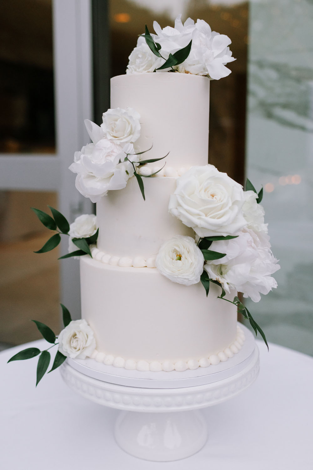 all white wedding cake with flowers