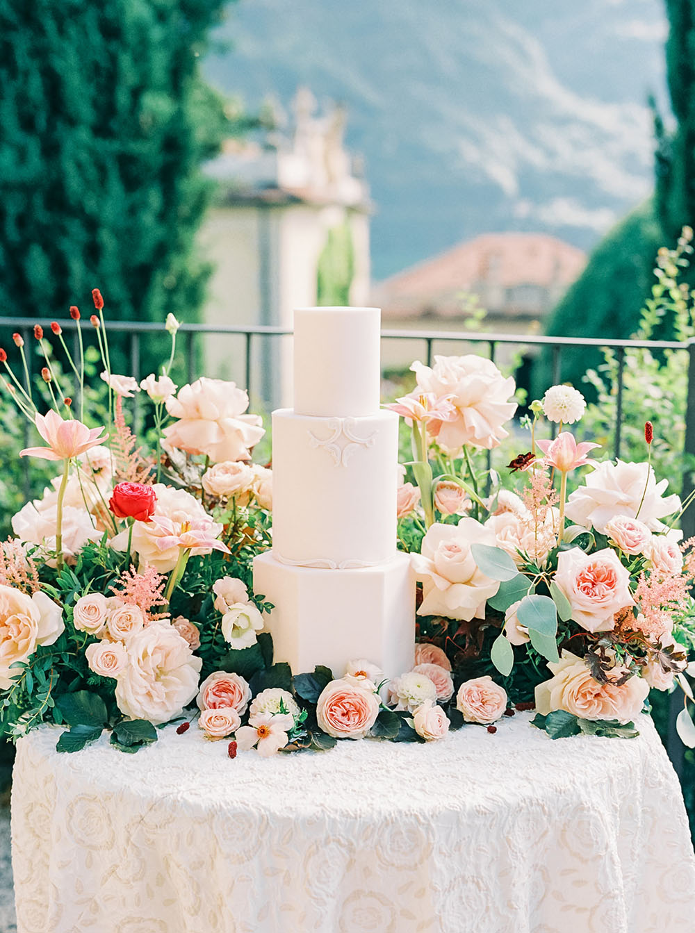 romantic wedding cake surrounded by lush spring wedding flowers