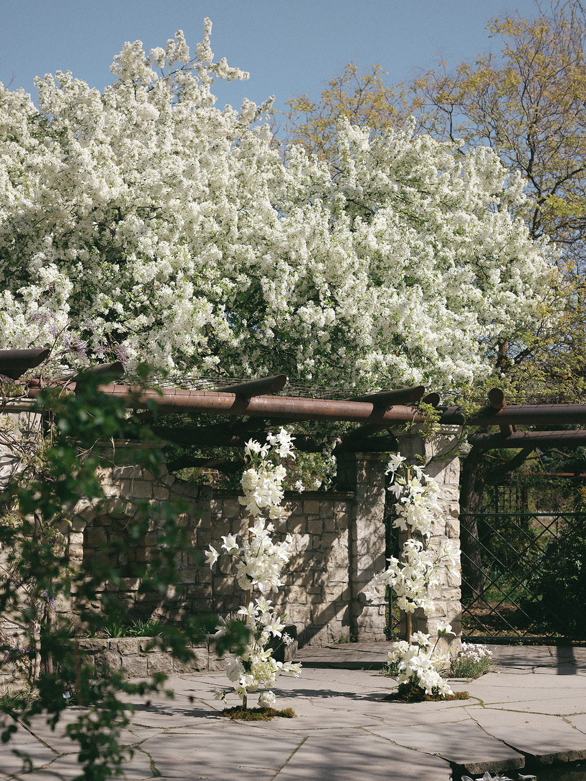 Tuscan-inspired outdoor ceremony with lush lily arrangements and vintage seating
