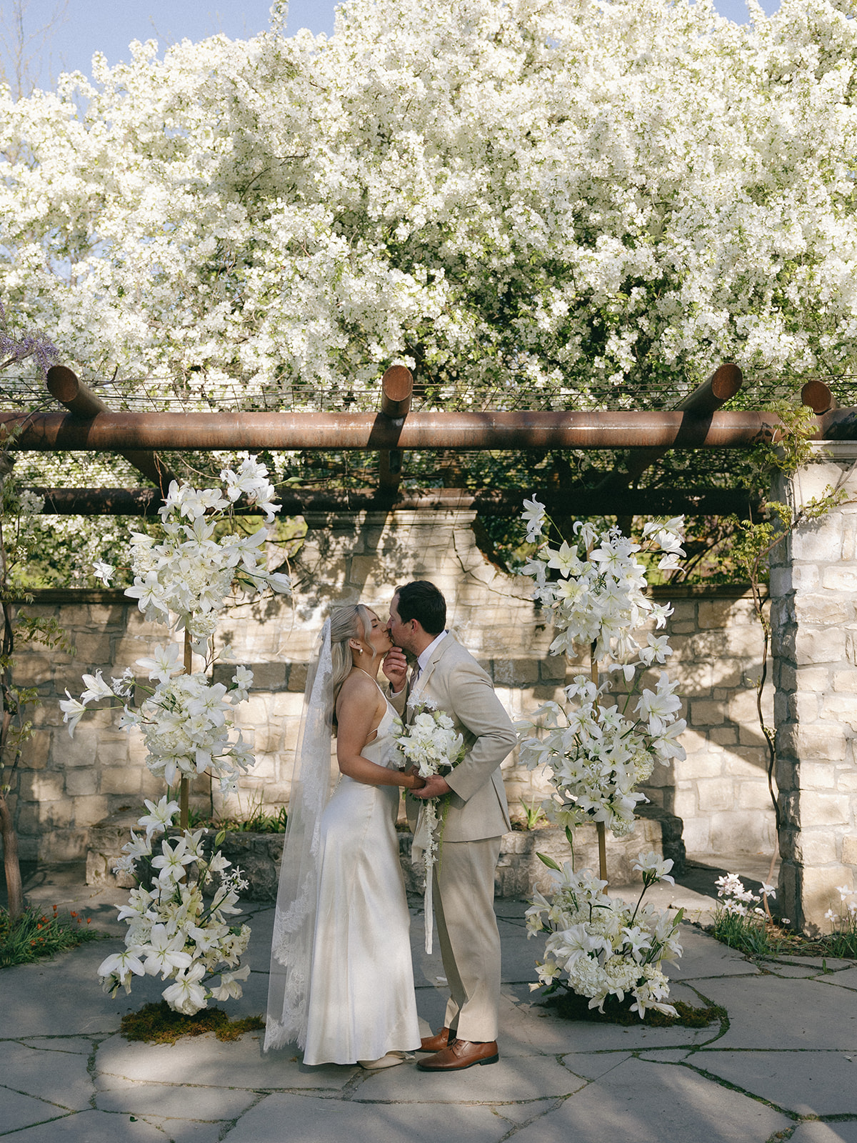 Tuscan-inspired outdoor ceremony with lush lily arrangements and vintage seating