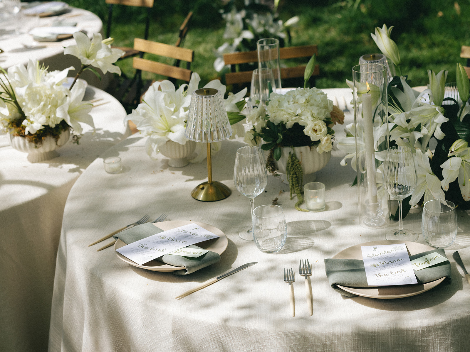 Stone flatware, crystal glassware, and handwritten menus at Tuscan garden reception table