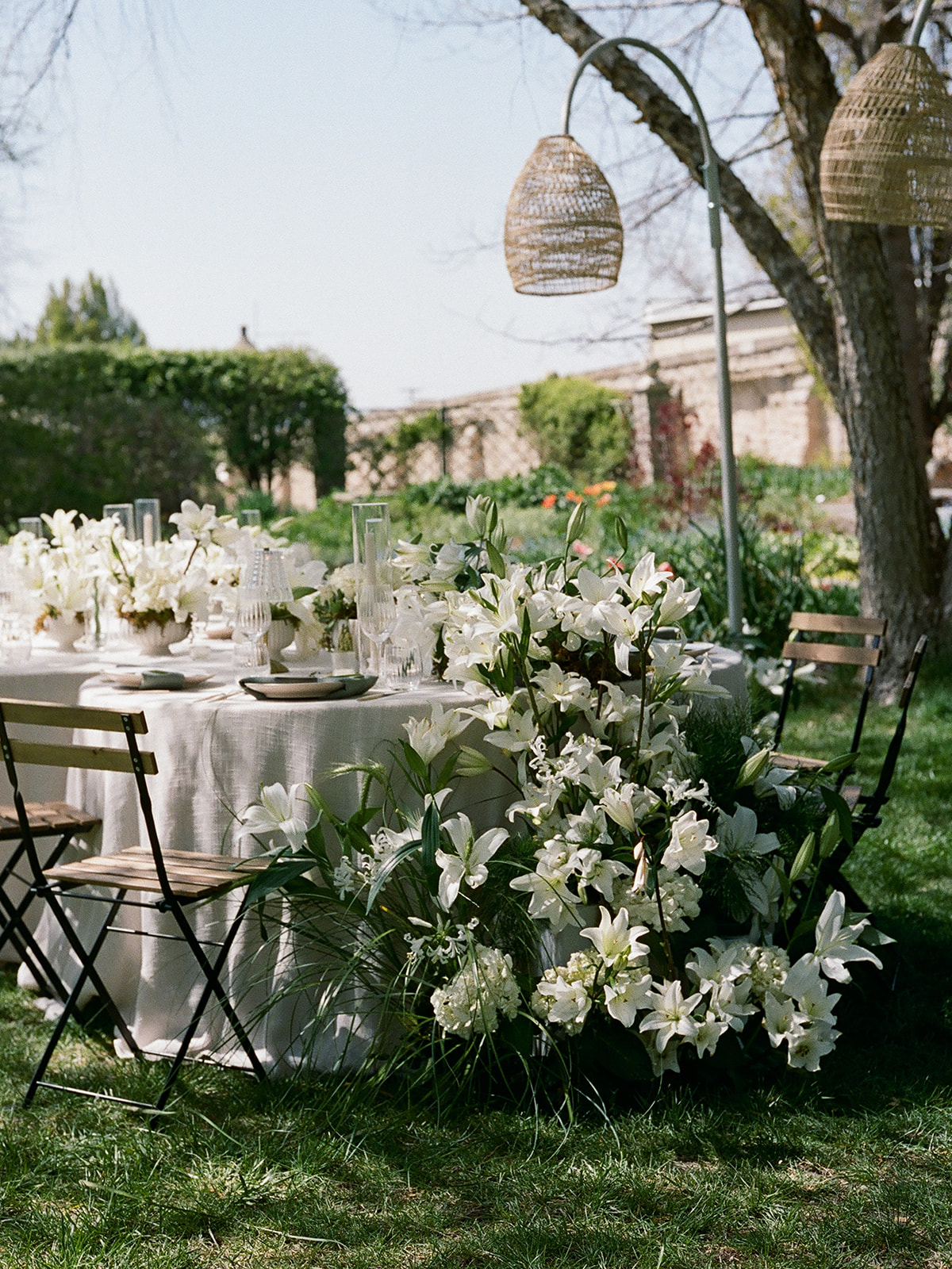 elegant garden wedding tablescape with linen tablecloths, vintage lamps, and spring florals