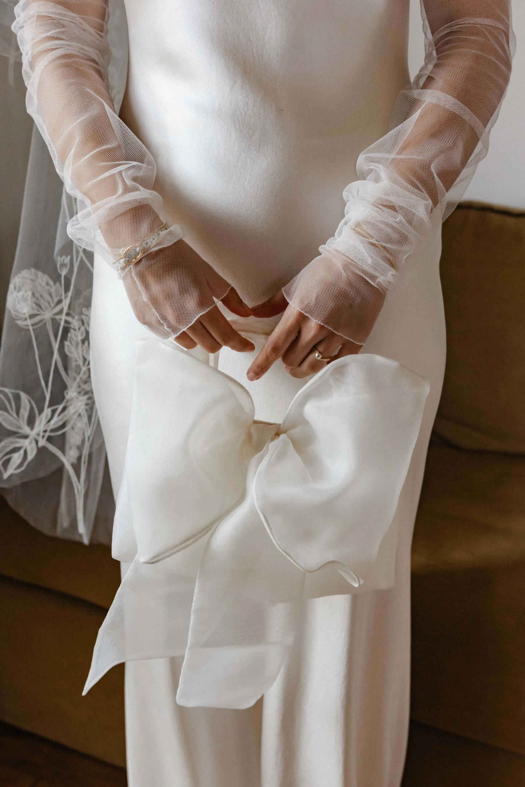 Elegant bride in a satin gown bow purse at a destination wedding in France.