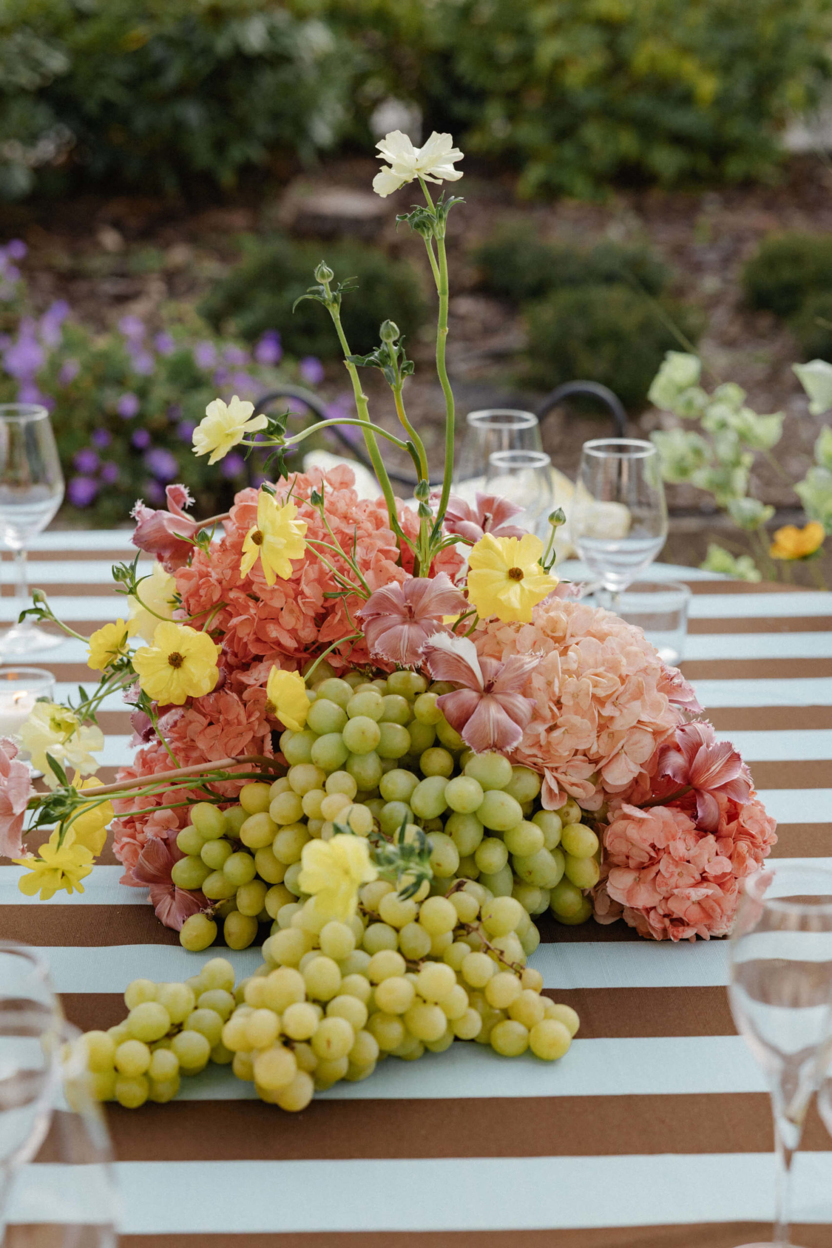 Unique wedding centerpiece combining colorful flowers with fruit centerpieces at a French château reception near Versailles