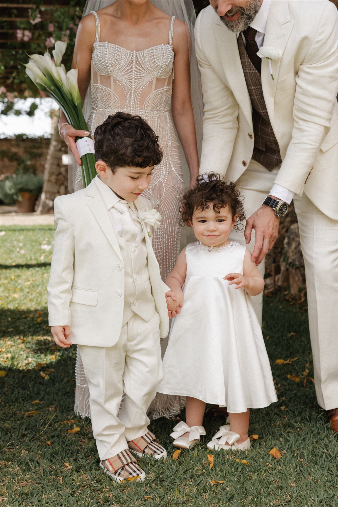 Young children dressed in white participating in destination wedding ceremony in Mallorca.