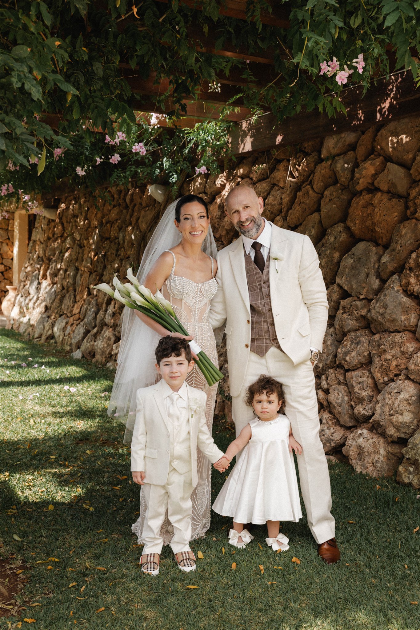 Young children dressed in white participating in destination wedding ceremony in Mallorca.