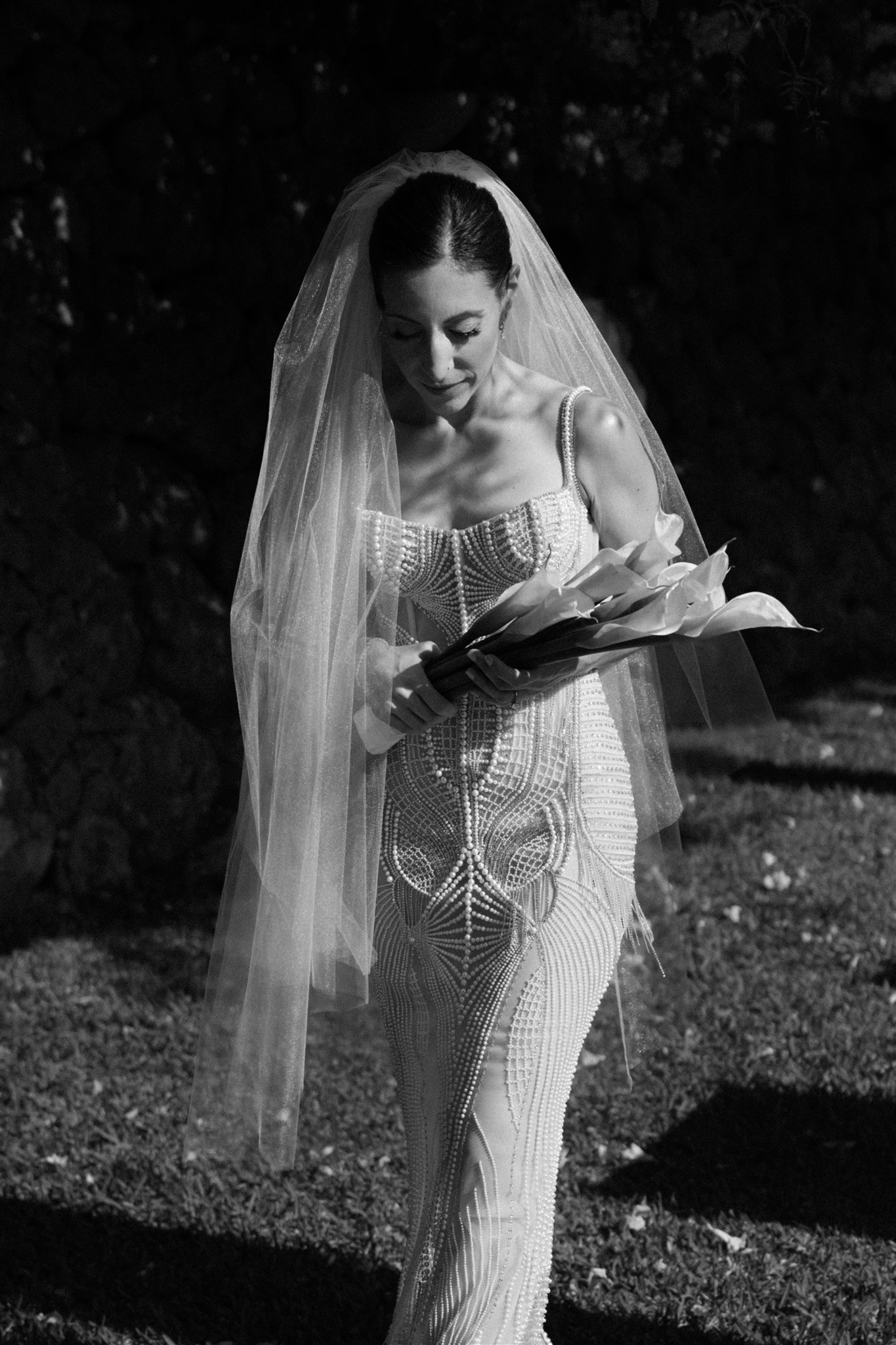 Bride wearing a Berta gown in Mallorca, walking through Mediterranean garden paths.