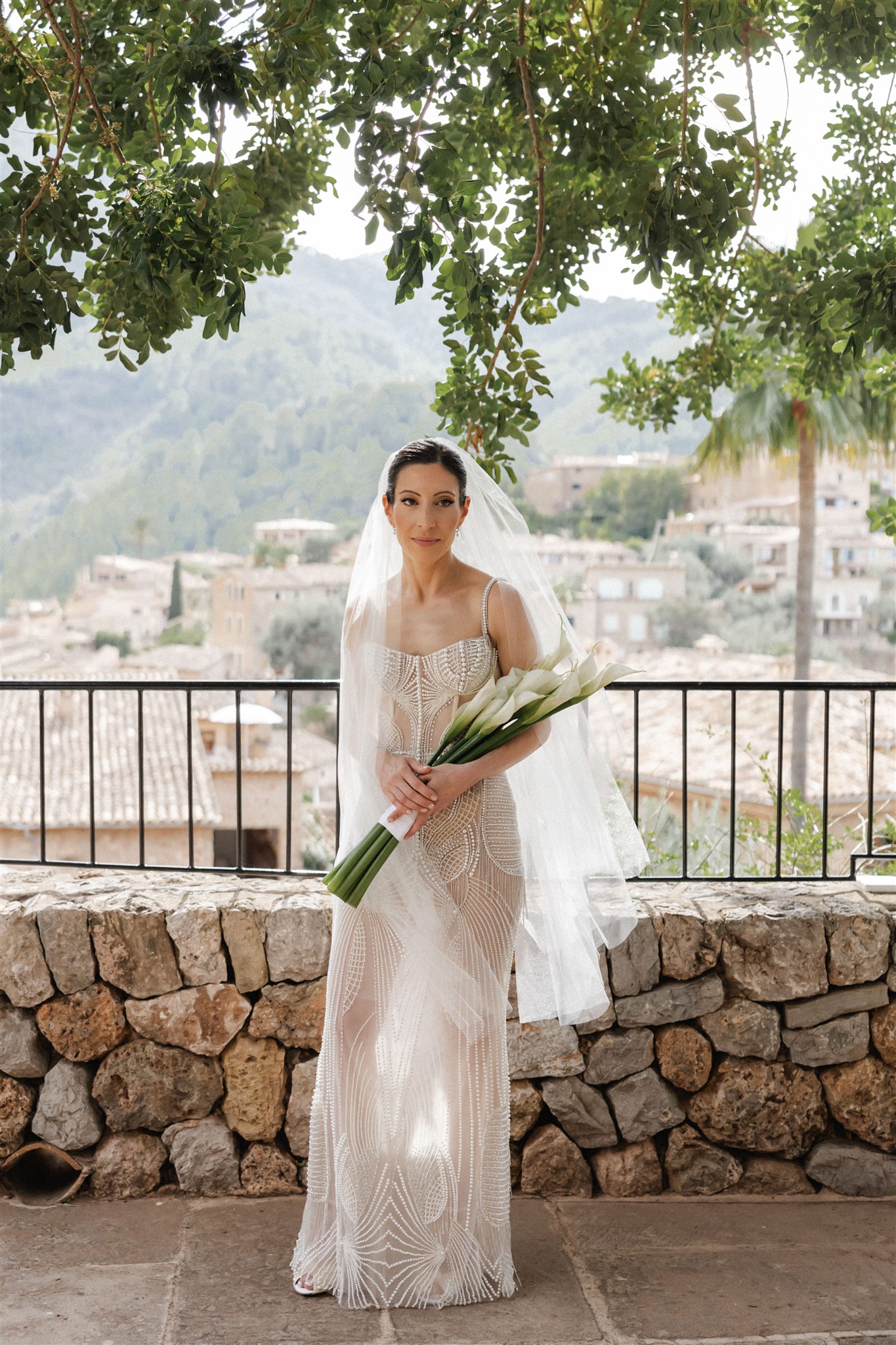 Bride wearing a Berta gown in Mallorca, walking through Mediterranean garden paths.