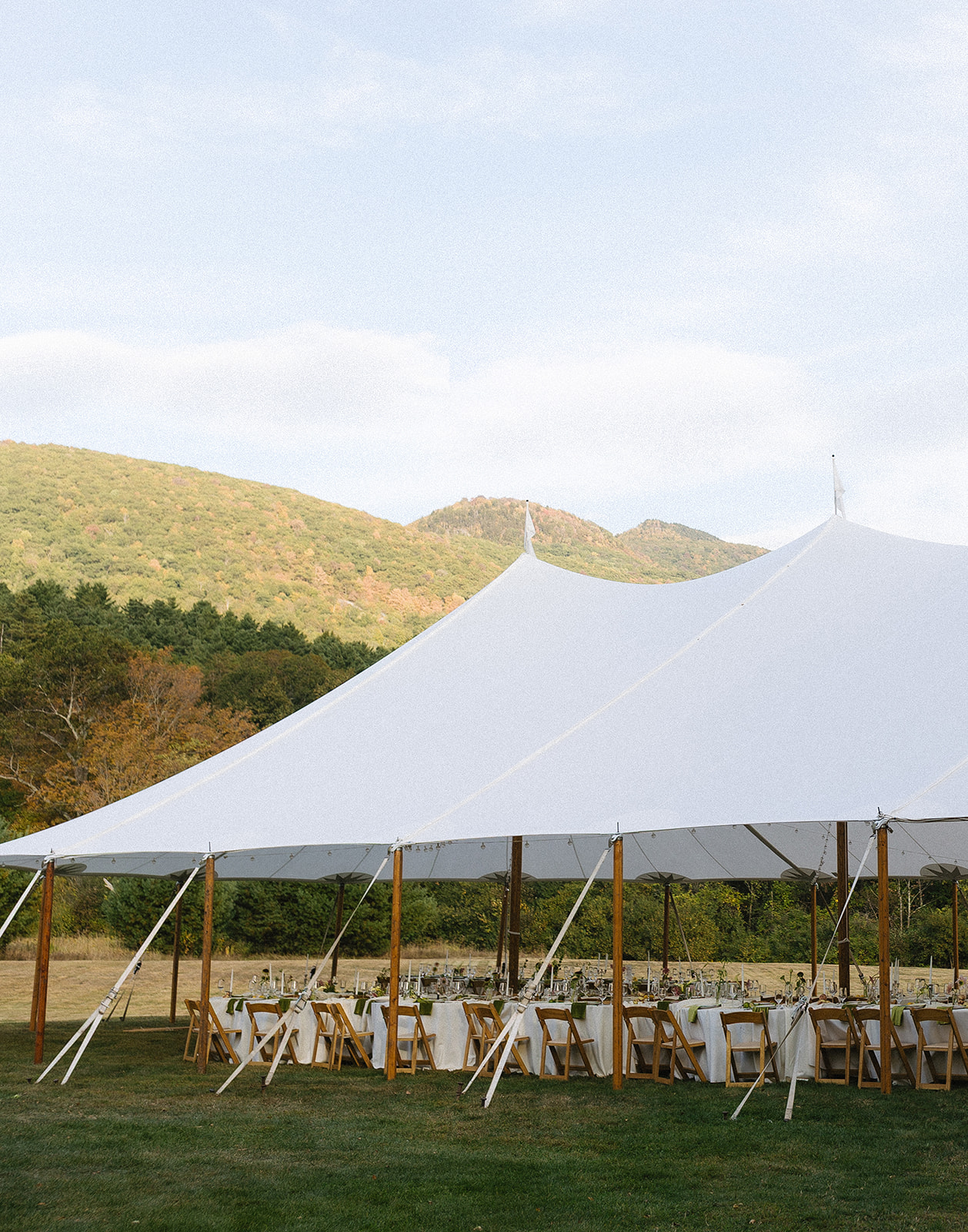 Romantic wedding reception at a private Vermont estate featuring vintage tables, classic florals, and an untraditional layout