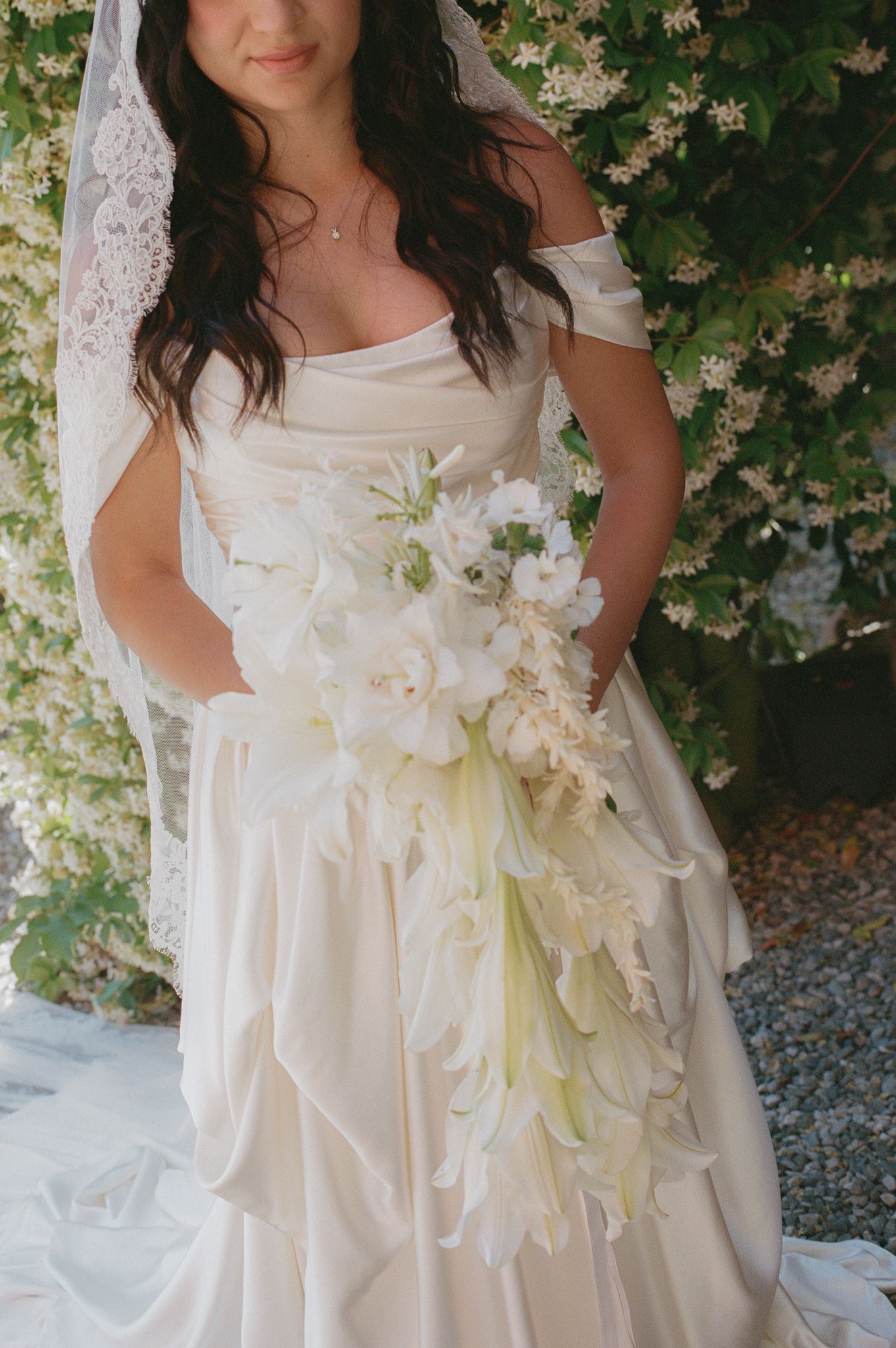 Cascading white bridal bouquet with lilies and soft trailing flowers