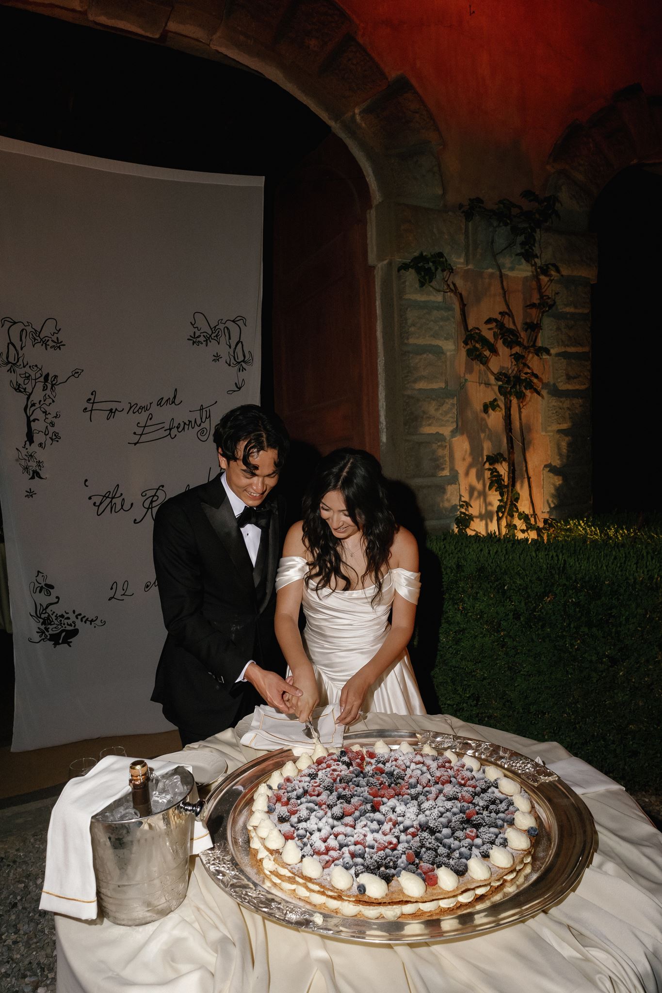 Bride and groom cutting their wedding cake during an intimate Italian villa reception