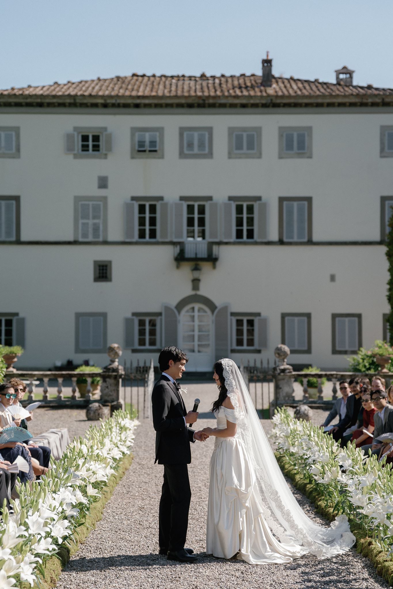 Bride and groom exchanging vows during an outdoor Italian villa wedding ceremony